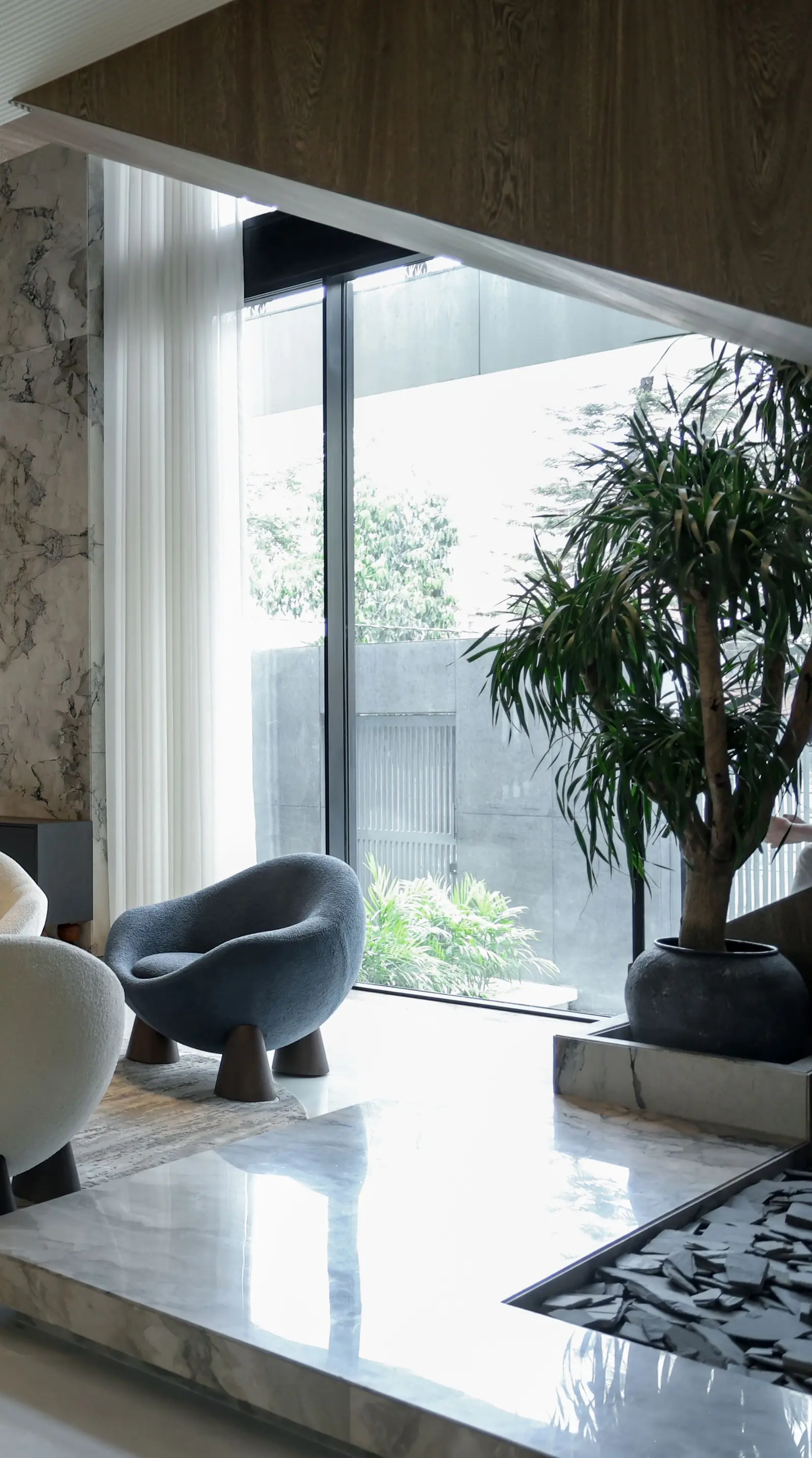 Sunlit living room with plants and soft neutral furnishings